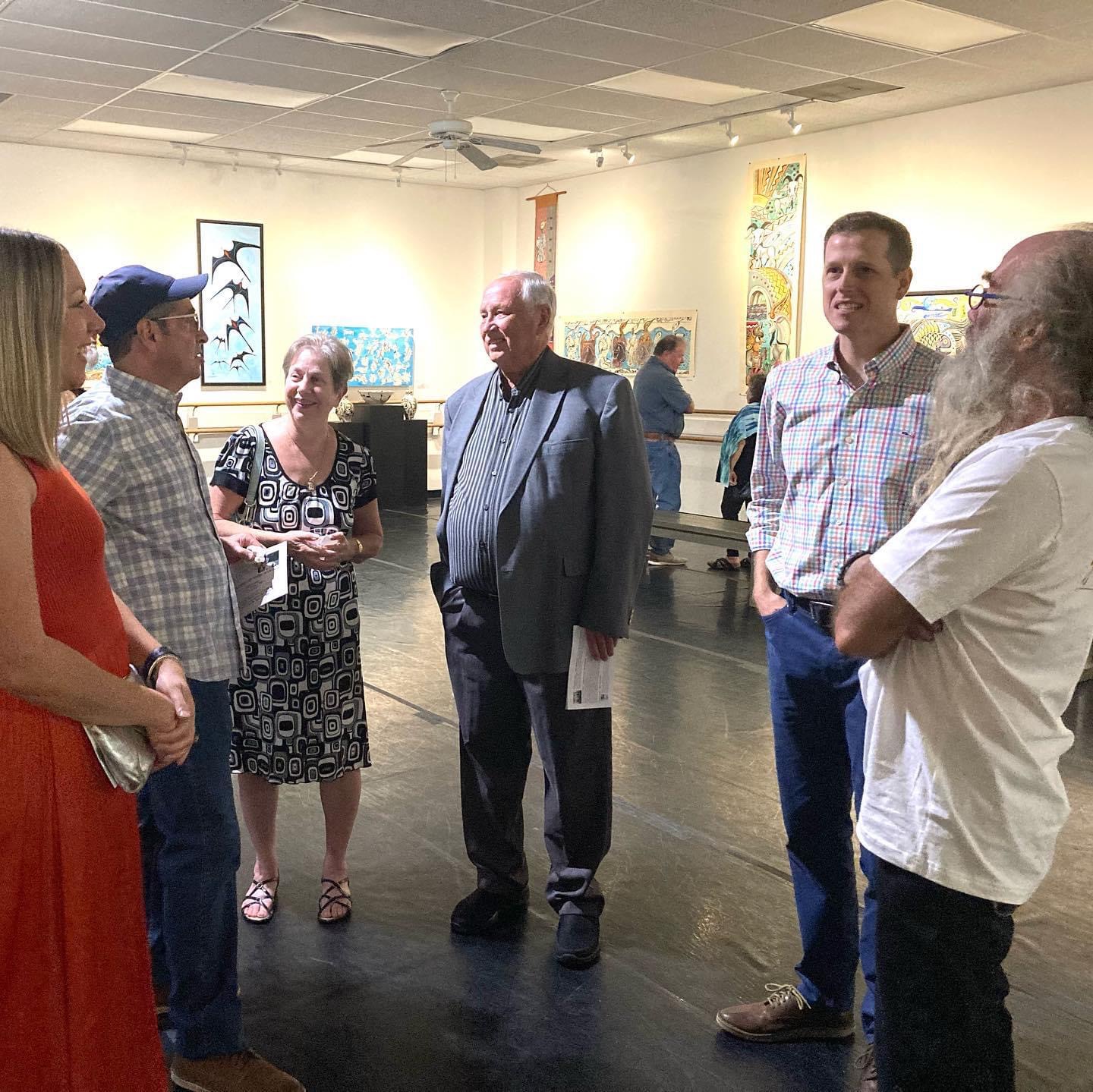 Patrons viewing artwork in the ArtWalk gallery, with the KFortier ballet barre in the background