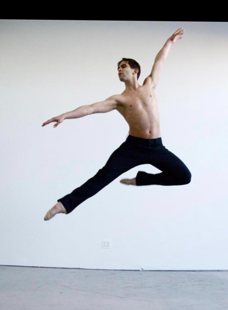 Tobin Eason leaping in a rehearsal studio